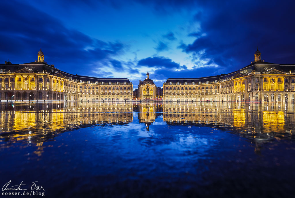 Die Gebäude auf dem Place de la Bourse spiegeln sich im Miroir d'Eau in Bordeaux