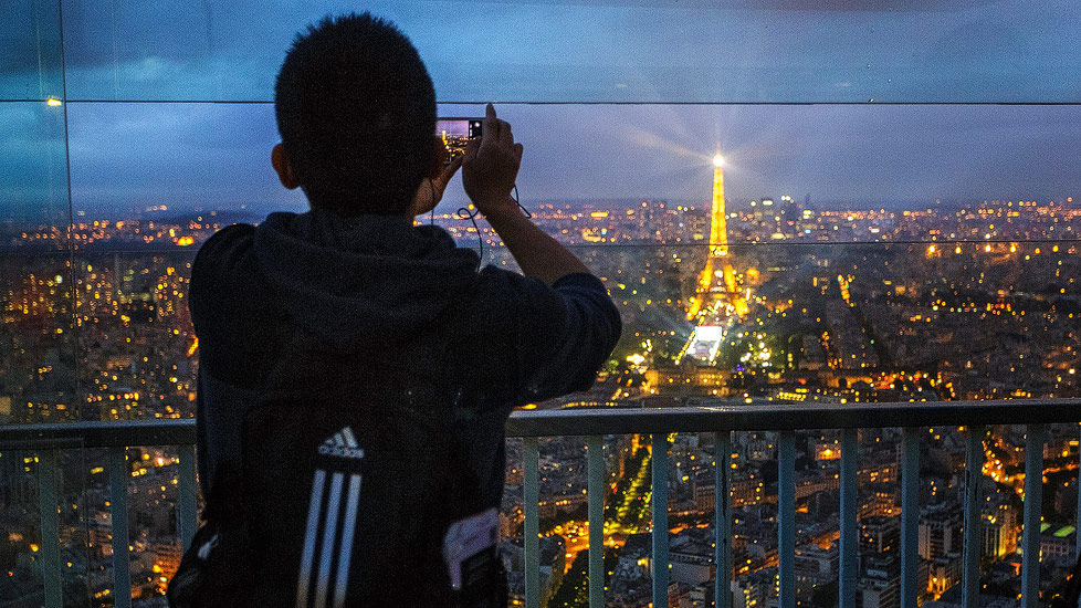Ein Tourist fotografiert auf der Aussichtsterrasse des Tour Montparnasse in Richtung Eiffelturm