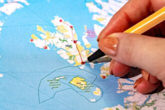 Person zeichnet auf einer Schottland-Karte die Highlights für eine Rundreise ein