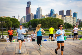 Läufer auf den Rocky Steps vor der Skyline von Philadelphia