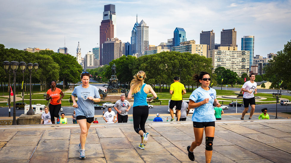 Läufer auf den Rocky Steps vor der Skyline von Philadelphia