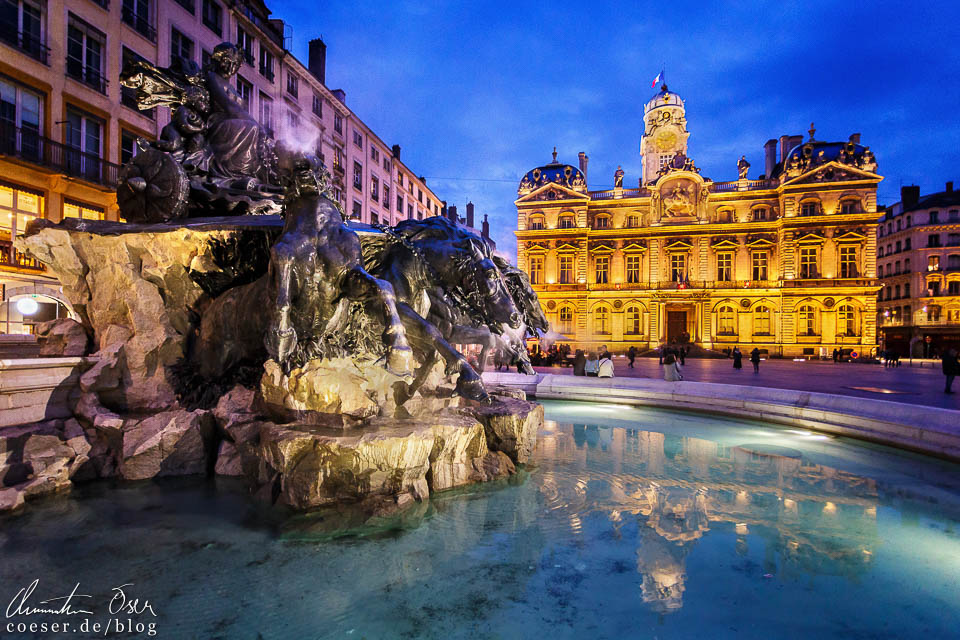 Abendaufnahme des Hôtel de ville und Fontaine de Bartholdi am Place des Terreaux in Lyon