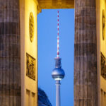 Blick durch das Brandenburger Tor auf den Fernsehturm kurz nach Sonnenuntergang in Berlin