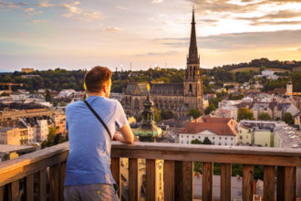 Mann blickt während eines Sonnenuntergangs auf Linz