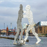 Das Kunstwerk "Molecule Man", dahinter die Oberbaumbrücke in Berlin