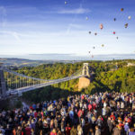 Zuschauer und Heißluftballons hinter der Clifton Suspension Bridge während der Bristol Balloon Fiesta