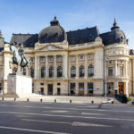 Die Hauptbibliothek mit der Reiterstatue von Karl I. auf dem Platz Piaţa Revoluţiei in Bukarest
