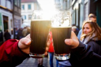 Zwei Personen stoßen mit Rauchbier der Brauerei Schlenkerla in Bamberg an