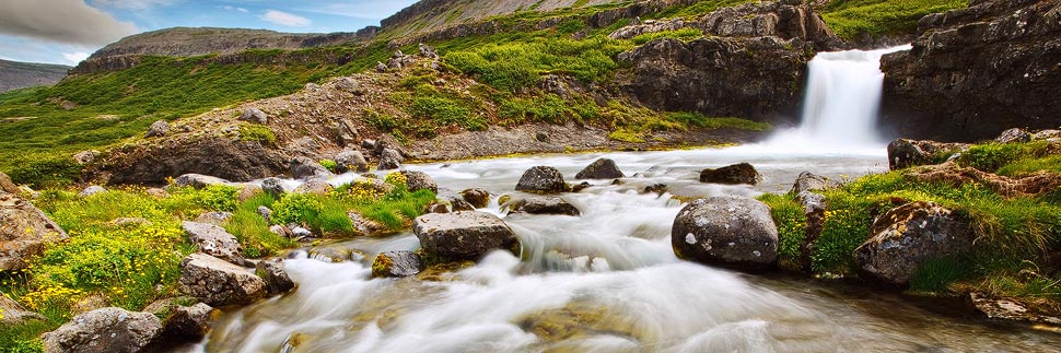 Landschaft mit kleinem Wasserfall und Fluss in Island