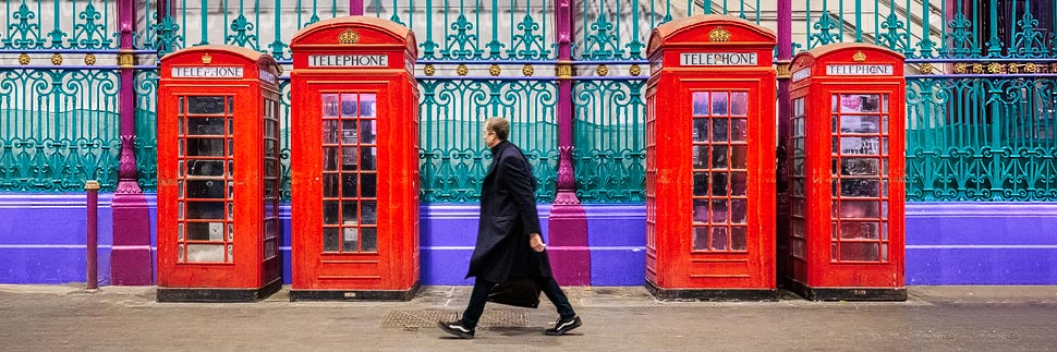 Mann geht an Telefonzellen in London vorbei