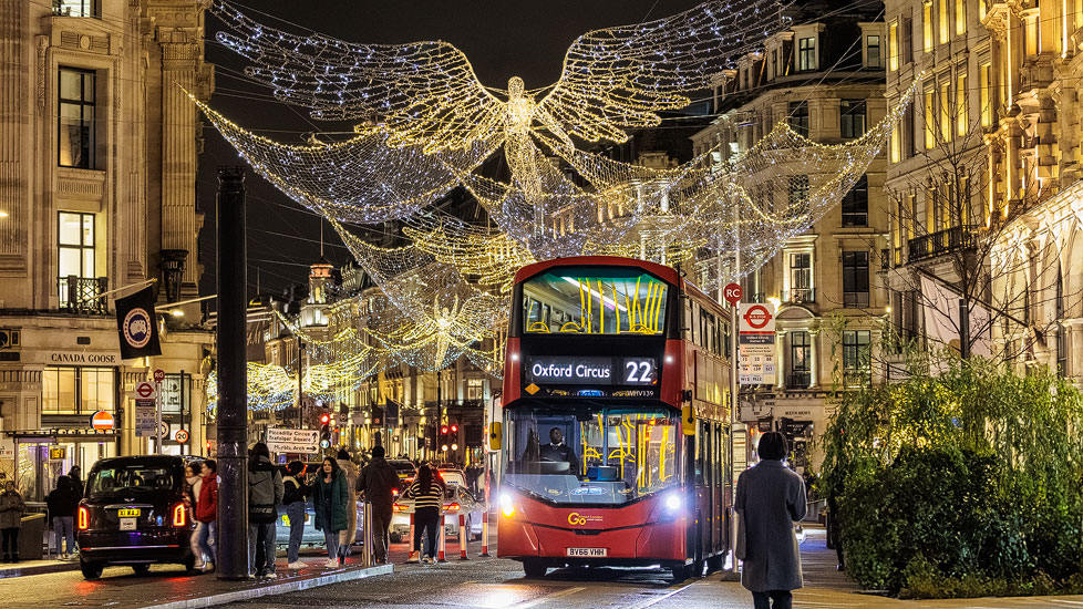 Roter Doppelstockbus zwischen der Weihnachtsbeleuchtung der Regent Street in London