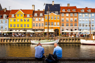 Zwei Männer entspannen am Hafen Nyhavn in Kopenhagen