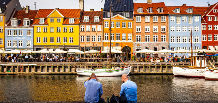 Zwei Männer entspannen am Hafen Nyhavn in Kopenhagen