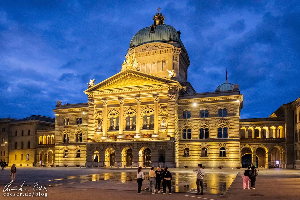 Außenansicht des beleuchteten Bundeshaus in Bern in der blauen Stunde