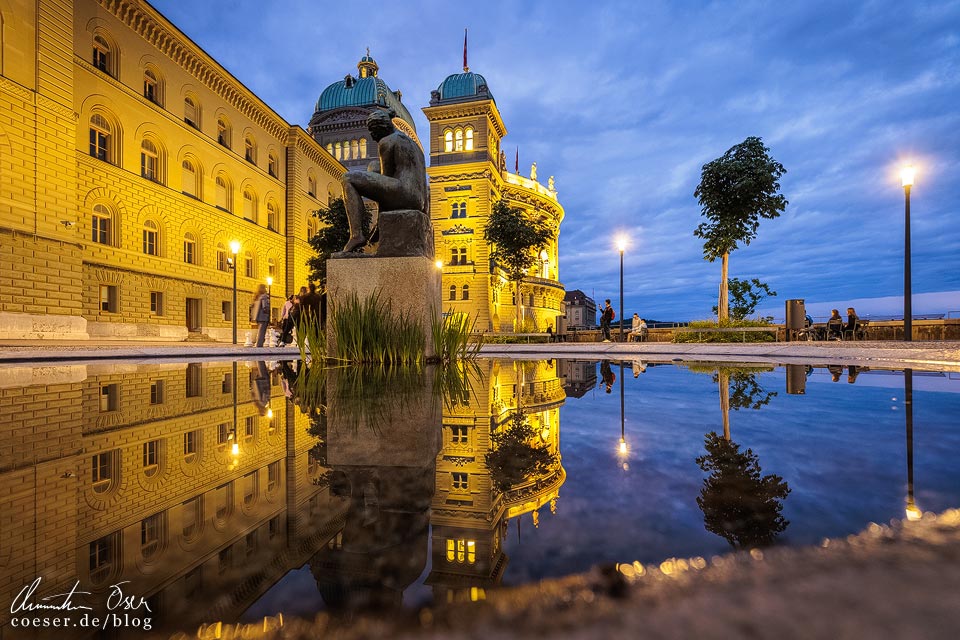 Spiegelung des beleuchteten Bundeshaus auf der Bundesterrasse in Bern in der blauen Stunde