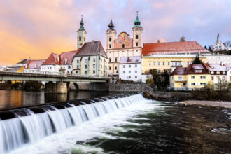 Sonnenaufgang über der Michaelerkirche und dem Fluss Steyr in Steyr, Oberösterreich