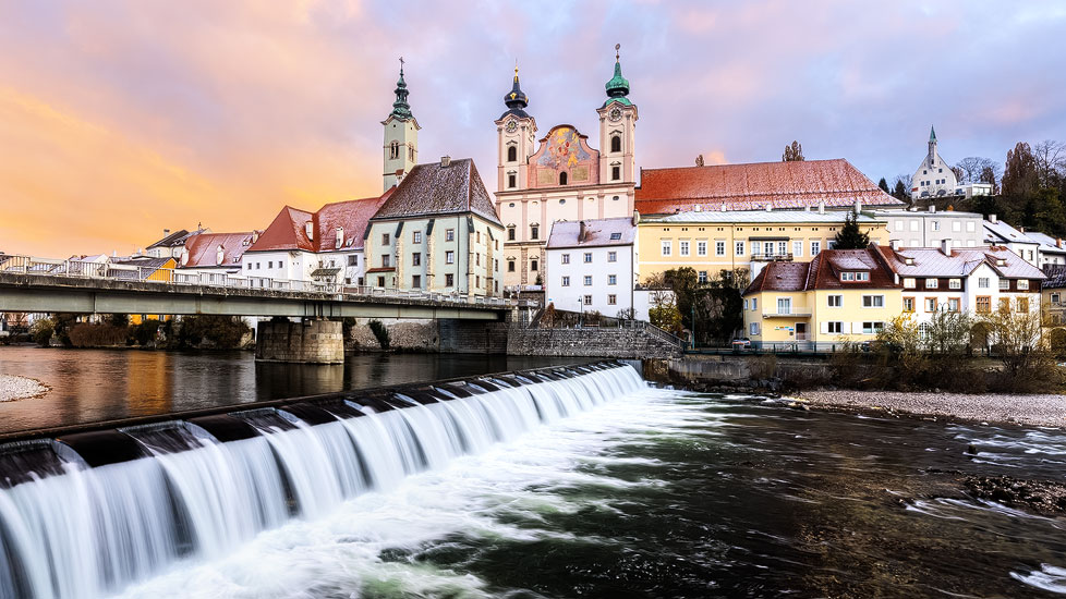 Sonnenaufgang über der Michaelerkirche und dem Fluss Steyr in Steyr, Oberösterreich