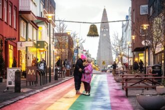 Ein Liebespaar auf der Regenbogenstraße mit Blick auf die Hallgrimskirche in Reykjavik
