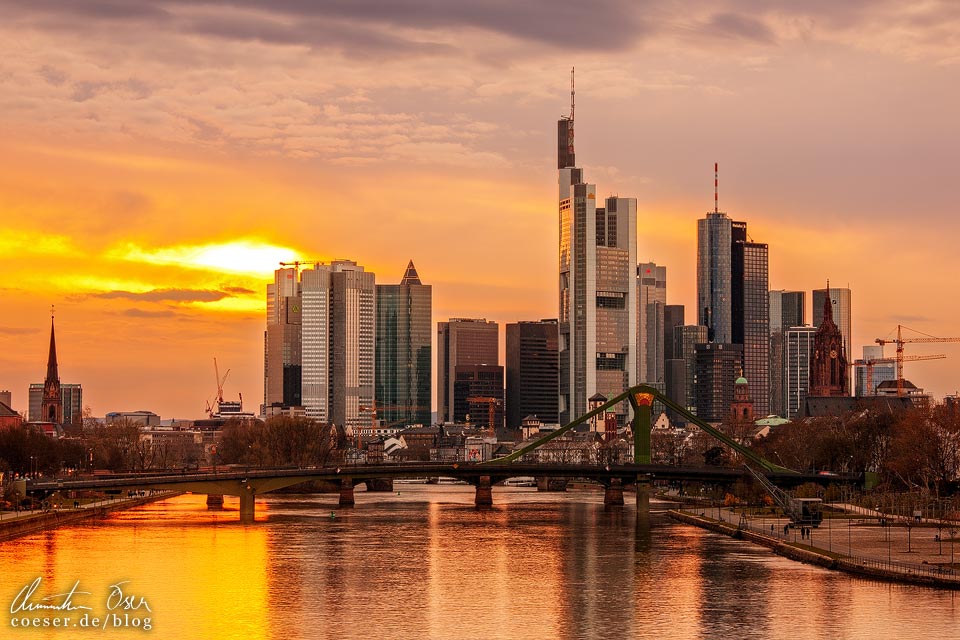 Blick von der Deutscherrnbrücke auf die Skyline von Frankfurt im Sonnenuntergang
