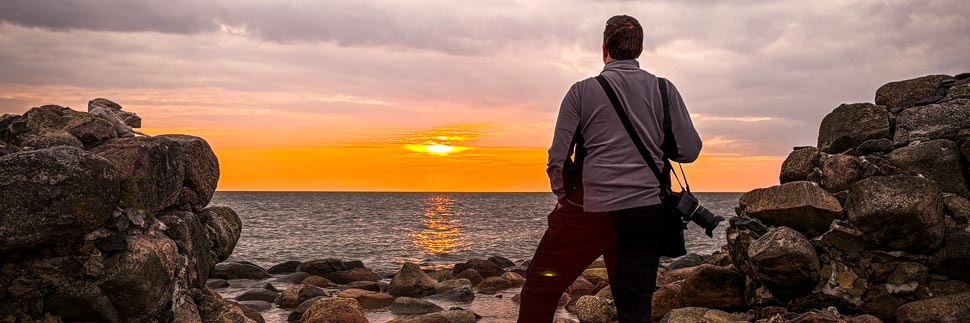 Fotograf Christian Öser während eines Sonnenaufgangs in Kap Kolka, Lettland