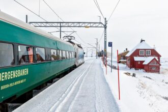 Ein Zug der Bergensbanen im verschneiten Bahnhof Finse, Norwegen