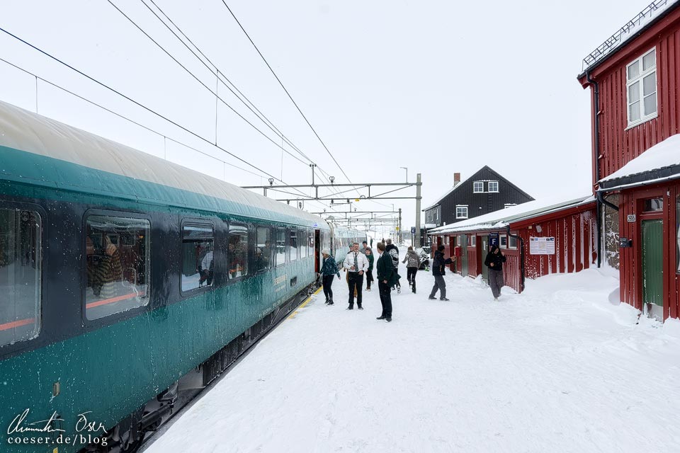 Zug der Bergensbanen im verschneiten Bahnhof Finse in Norwegen