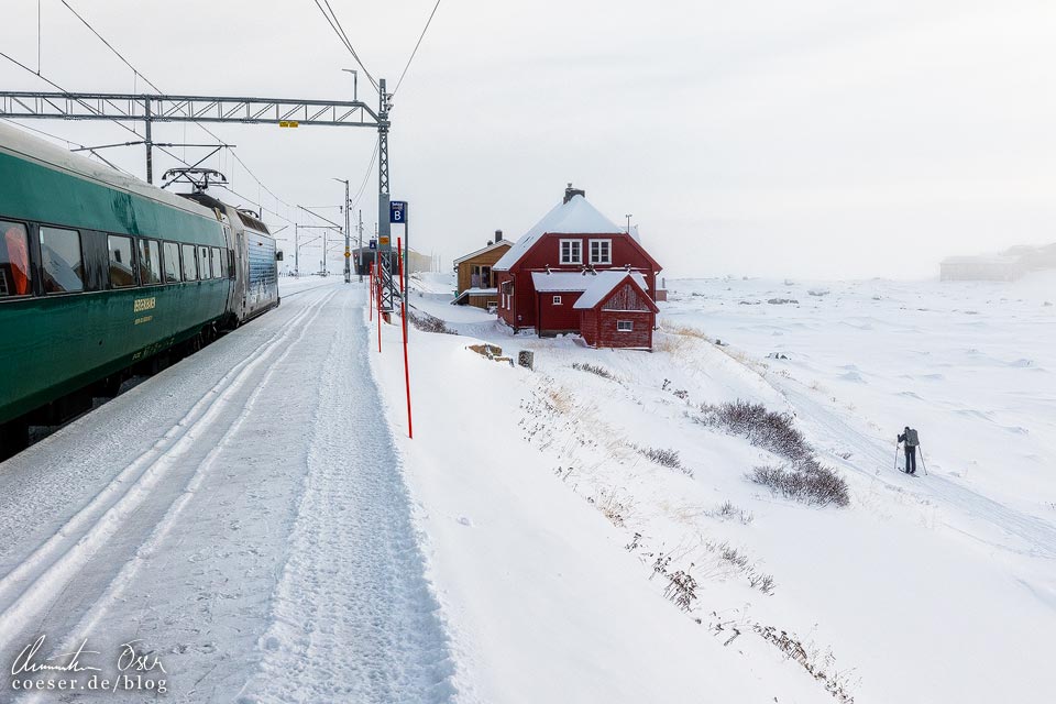 Ein Zug der Bergensbanen im tiefverschneiten Bahnhof Finse in Norwegen