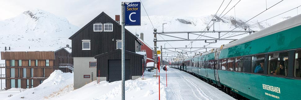 Ein Zug der Bergensbanen im verschneiten Bahnhof Finse, Norwegen