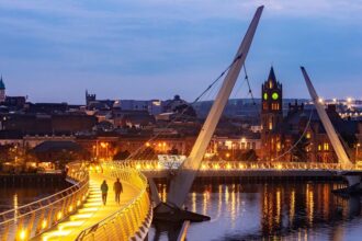Abendaufnahme der beleuchteten Peace Bridge in Derry-Londonderry, Nordirland
