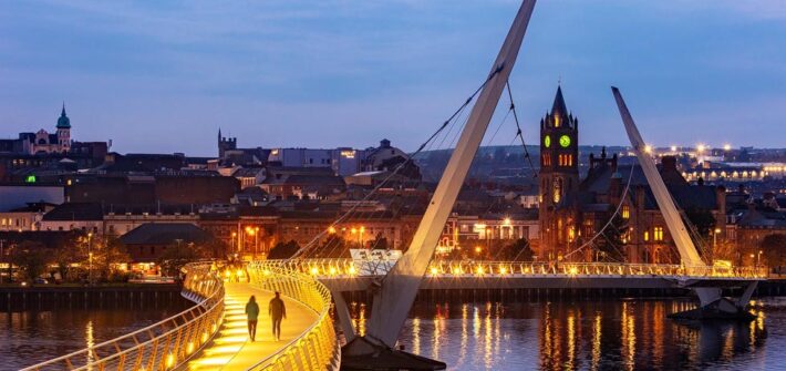 Abendaufnahme der beleuchteten Peace Bridge in Derry-Londonderry, Nordirland