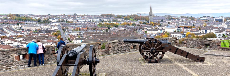 Kanonen auf der Stadtmauer mit Ausblick auf das Viertel Bogside in Derry/Londonderry, Nordirland