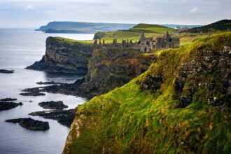 Blick auf das Dunluce Castle und die Küstenlandschaft an der Causeway Coastal Route in Nordirland
