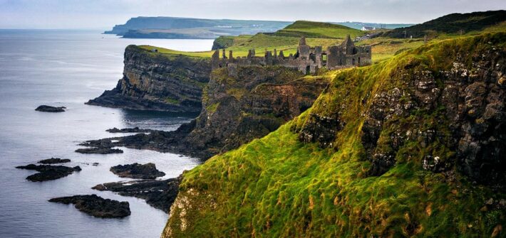 Blick auf das Dunluce Castle und die Küstenlandschaft an der Causeway Coastal Route in Nordirland