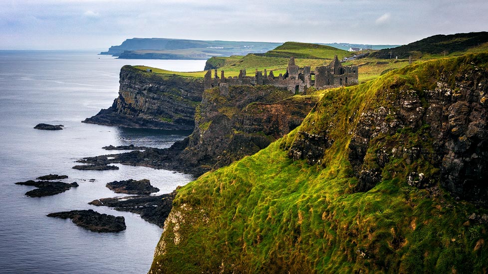 Blick auf das Dunluce Castle und die Küstenlandschaft an der Causeway Coastal Route in Nordirland