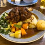 Lamb Shank mit Püree und Gemüse im Pub The Glencloy Inn in Carnlough, Nordirland