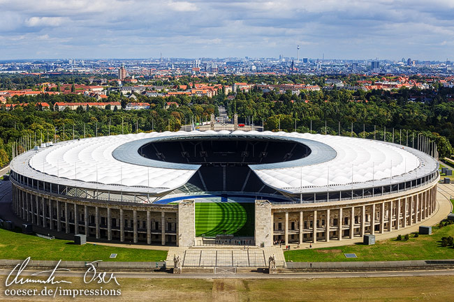 Blick auf das Olympiastadion und die Skyline Berlins im Hintergrund in Berlin, Deutschland.
