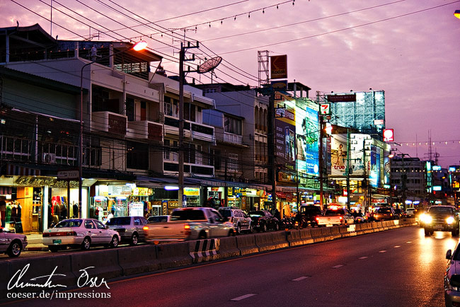 Ein magentafarbener Sonnenuntergang beleuchtet die Hauptstraße von Hua Hin, Thailand.
