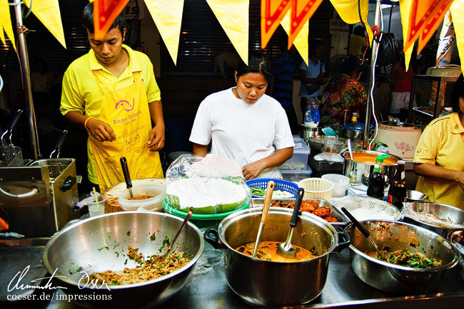 Zwei Einheimische bereiten in einer Garküche Essen vor in Hua Hin, Thailand.