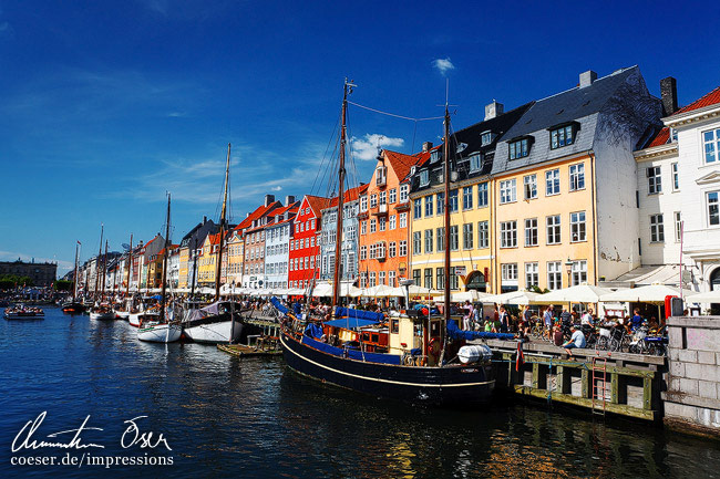 Bunte Stadthäuser und vor Anker liegende Schiffe am Nyhavn-Hafen in Kopenhagen, Dänemark.