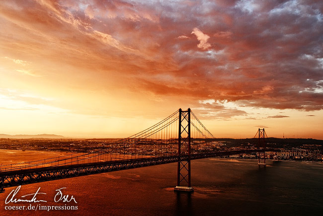 Spektakulärer Sonnenuntergang über der Ponte 25 de Abril Brücke in Lissabon, Portugal.