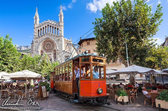 Eine Straßenbahn vor der Sant-Bartomeu-Kirche in Soller auf der Insel Mallorca, Spanien.
