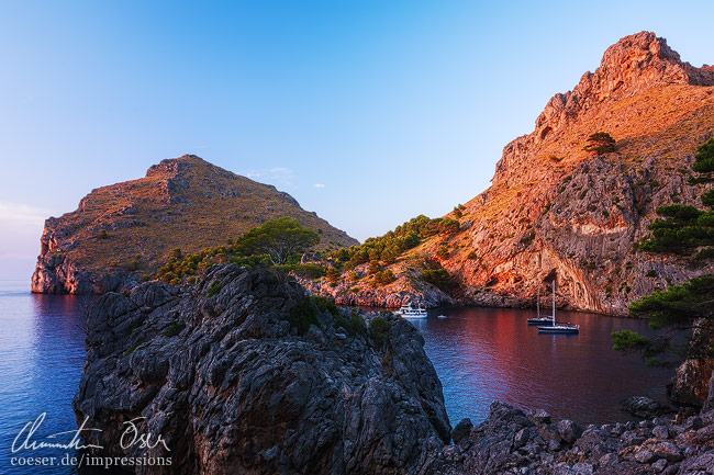 Boote treiben in der Bucht Sa Calobra wärend eines Sonnenuntergangs auf der Insel Mallorca, Spanien.