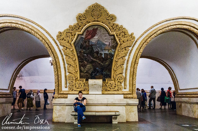 Eine Frau wartet auf einen Zug in der U-Bahn-Station Kiewskaja (Kiewer Bahnhof) in Moskau, Russland.