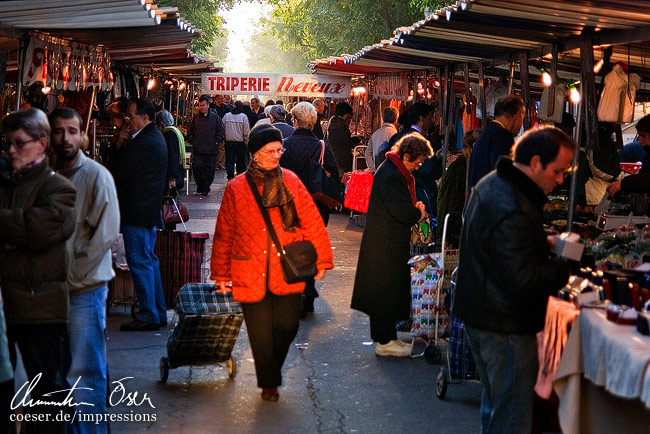 Eine Frau geht auf einem Flohmarkt entlang von Verkaufsständen in Paris, Frankreich.