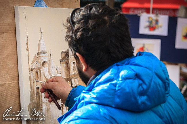 Ein Künstler erstellt ein Gemälde im Montmartre-Viertel in Paris, Frankreich.