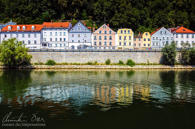 Spiegelung bunter Häuser entlang der Donau in Passau, Deutschland.