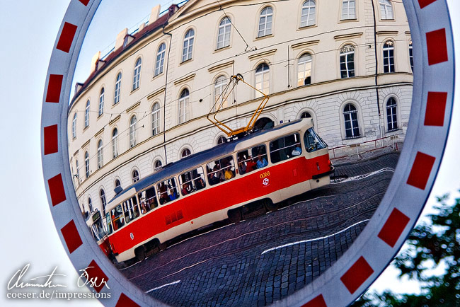 Eine Straßenbahn spiegelt sich in einem Verkehrsspiegel in Prag, Tschechien.