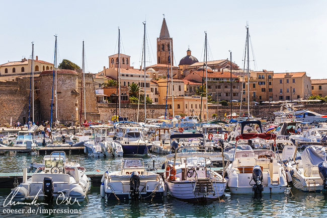 Einige Boote ankern im Hafen der Stadt Alghero auf der Insel Sardinien, Italien.
