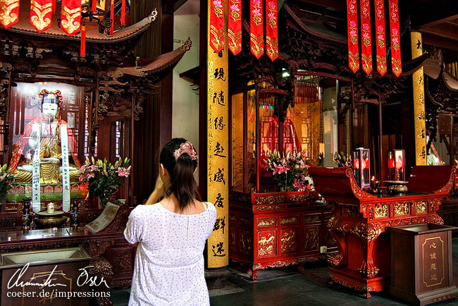 Eine Frau betet im Jadebuddha-Tempel in Shanghai, China.