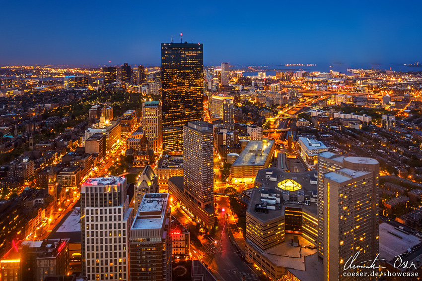 Beleuchtete Skyline von Boston und den Prudential Tower während eines Sonnenuntergangs in Boston, USA.